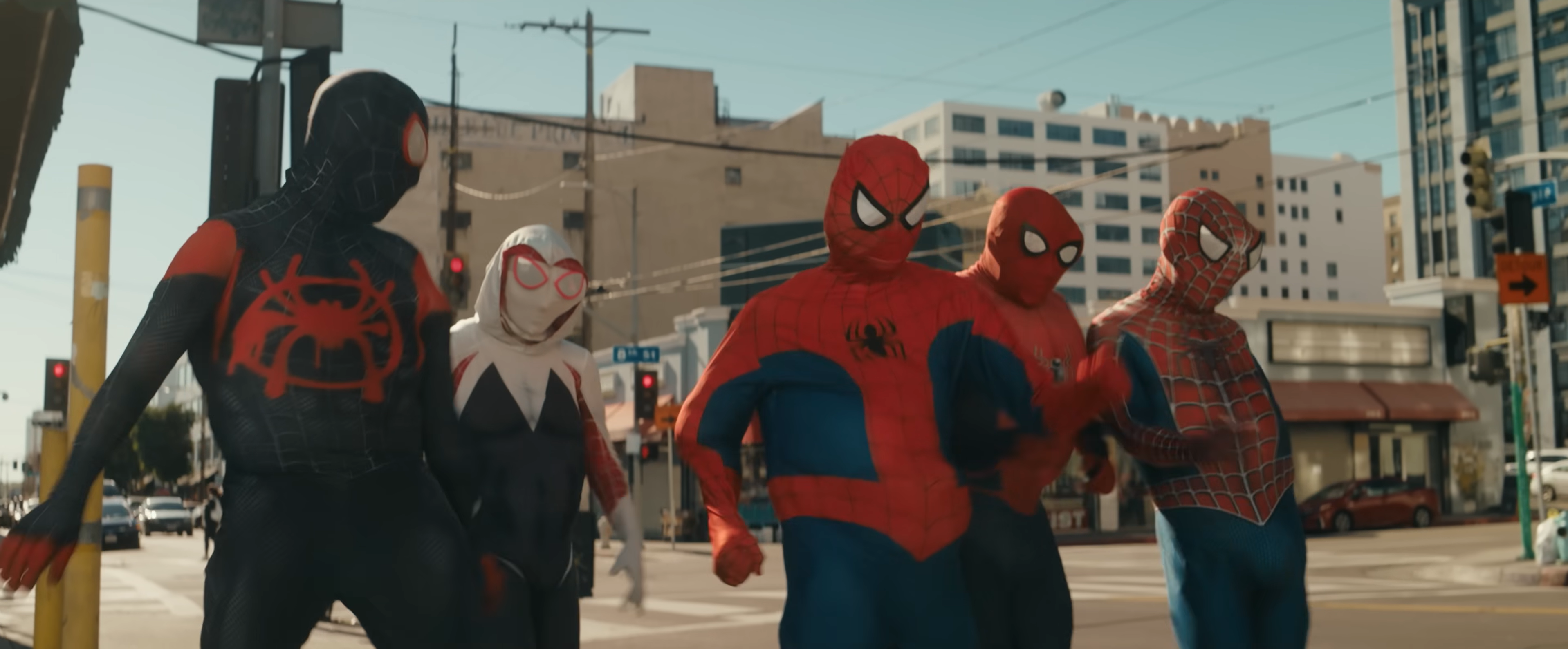A group of playful Spooder-Man characters moving through a city