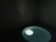 Reference render: a dim grotto, a faint patch of reflected sunlight on the back wall, and a teal pool with a bright patch of refracted sunlight on its floor
